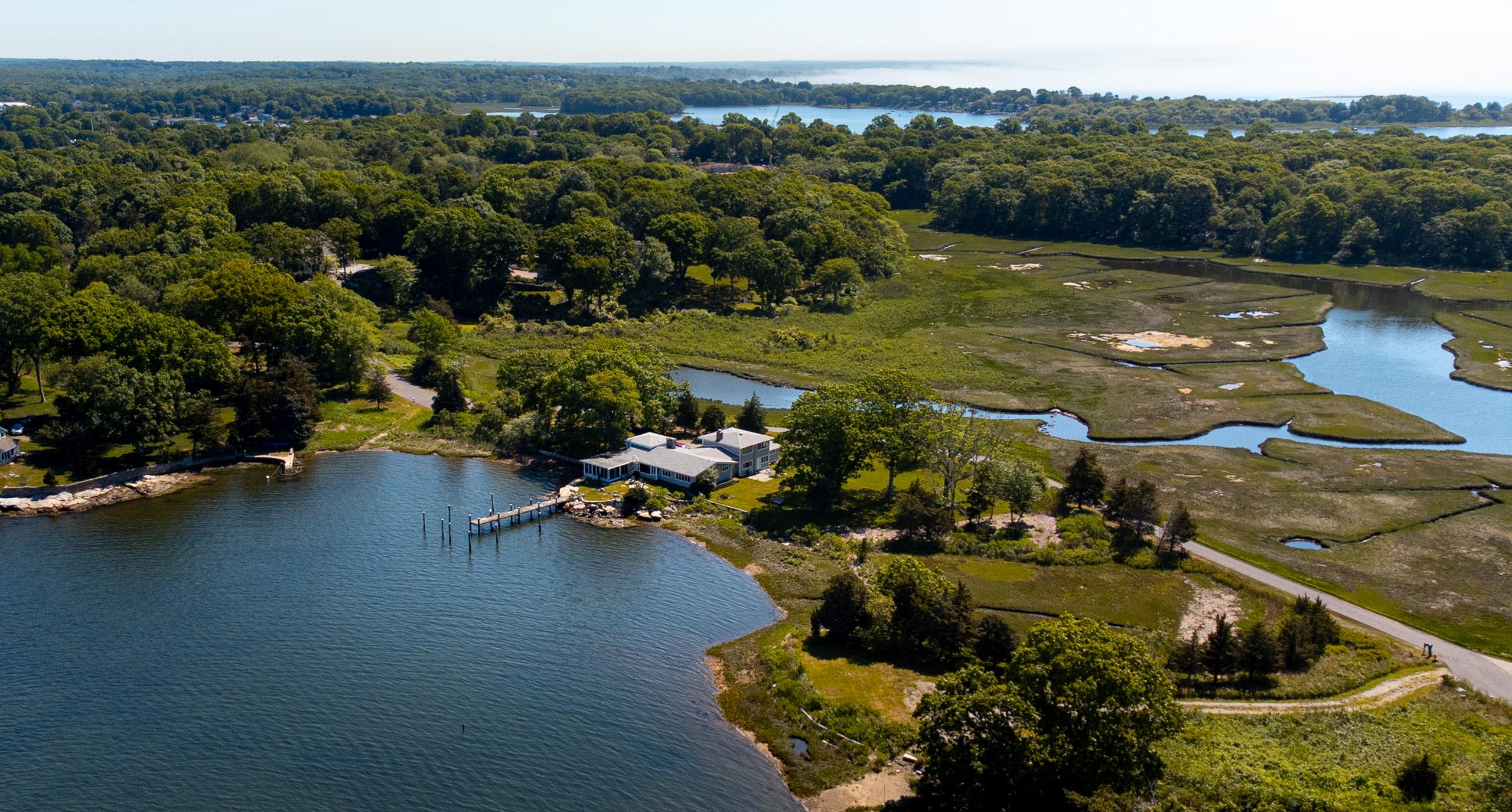 The house on its point: the lawn and dock on the river side, the wetlands stretching behind.