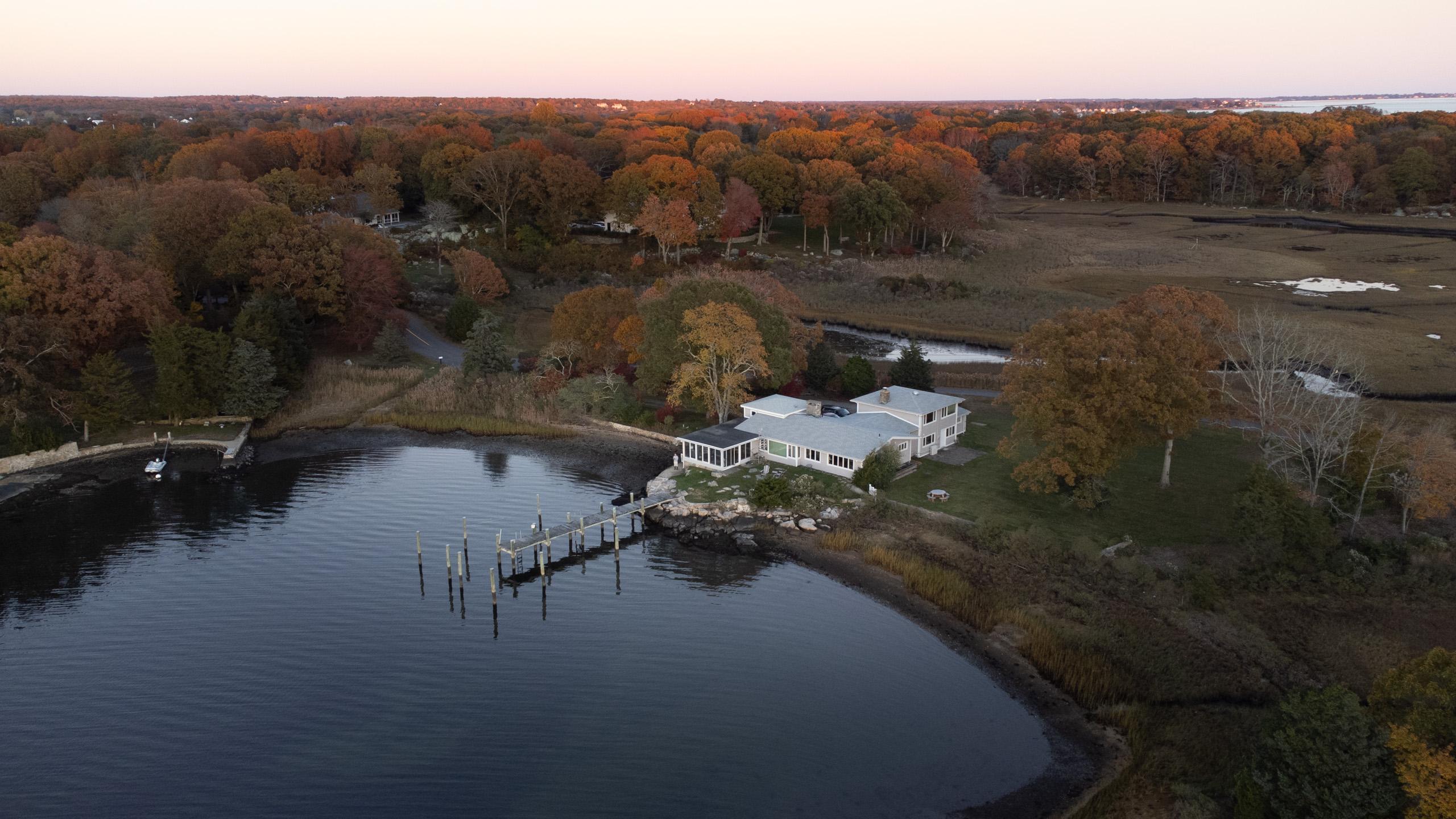 The house at autumn dusk: the cove, the dock, and the wetlands behind. In the family since 1946.
