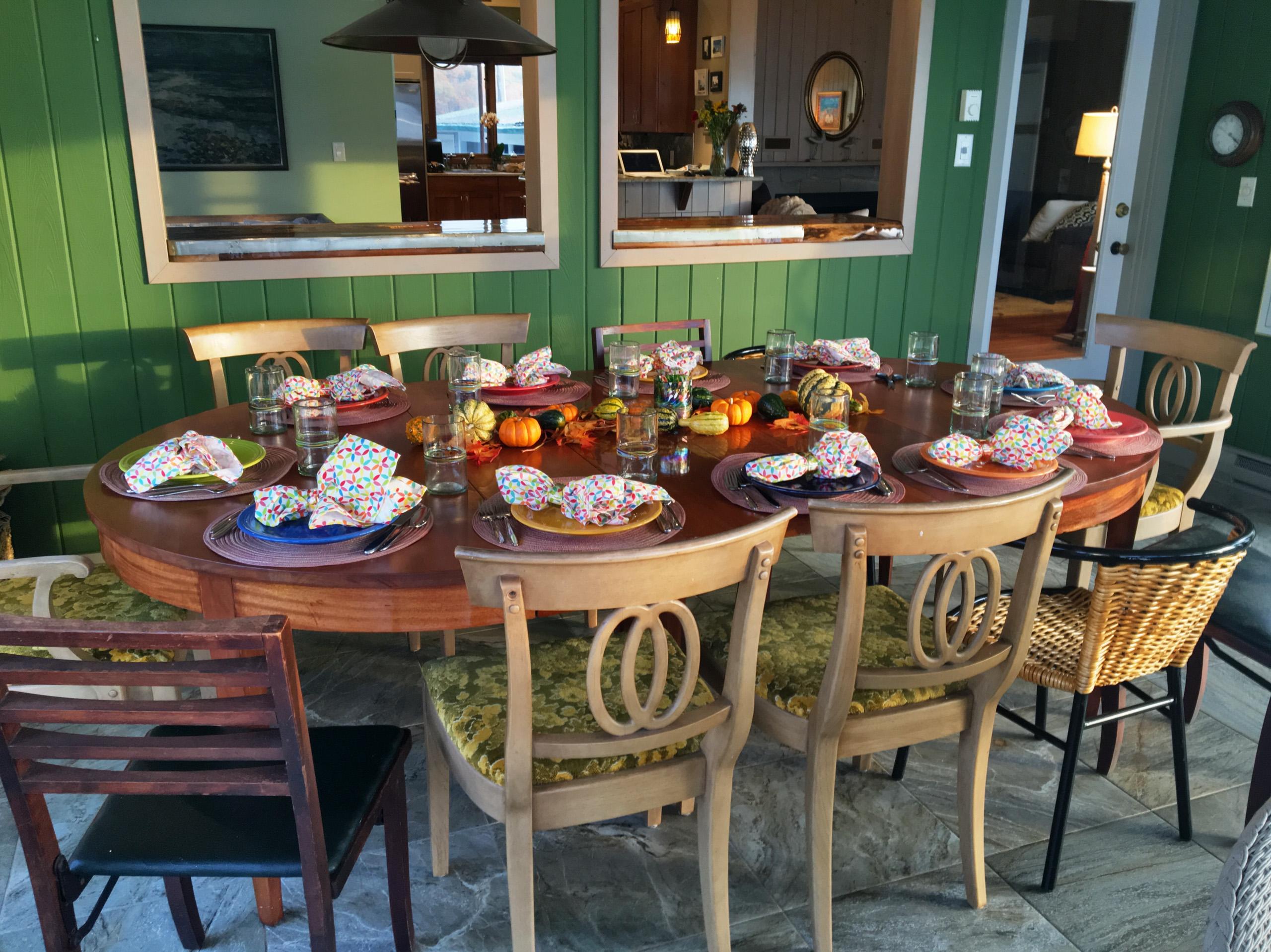 The dining table in the sunroom, set against the water.