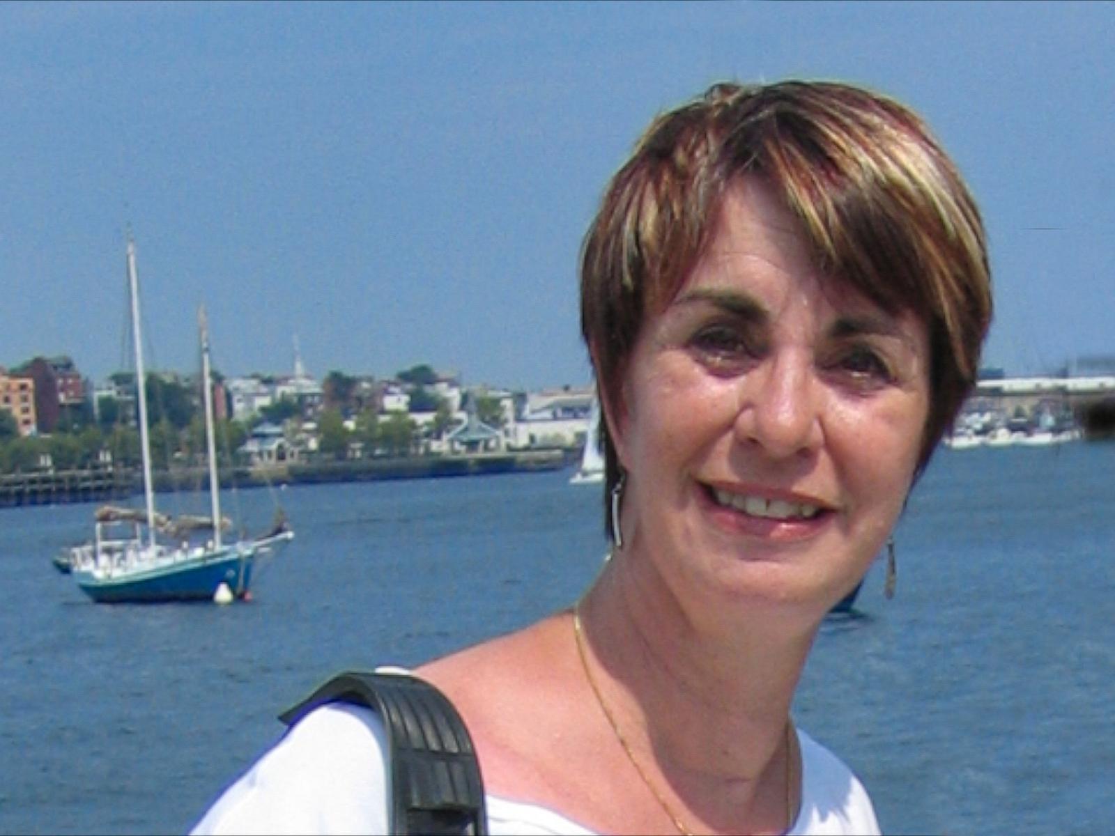 Glori at the harbor, a sailboat moored behind her