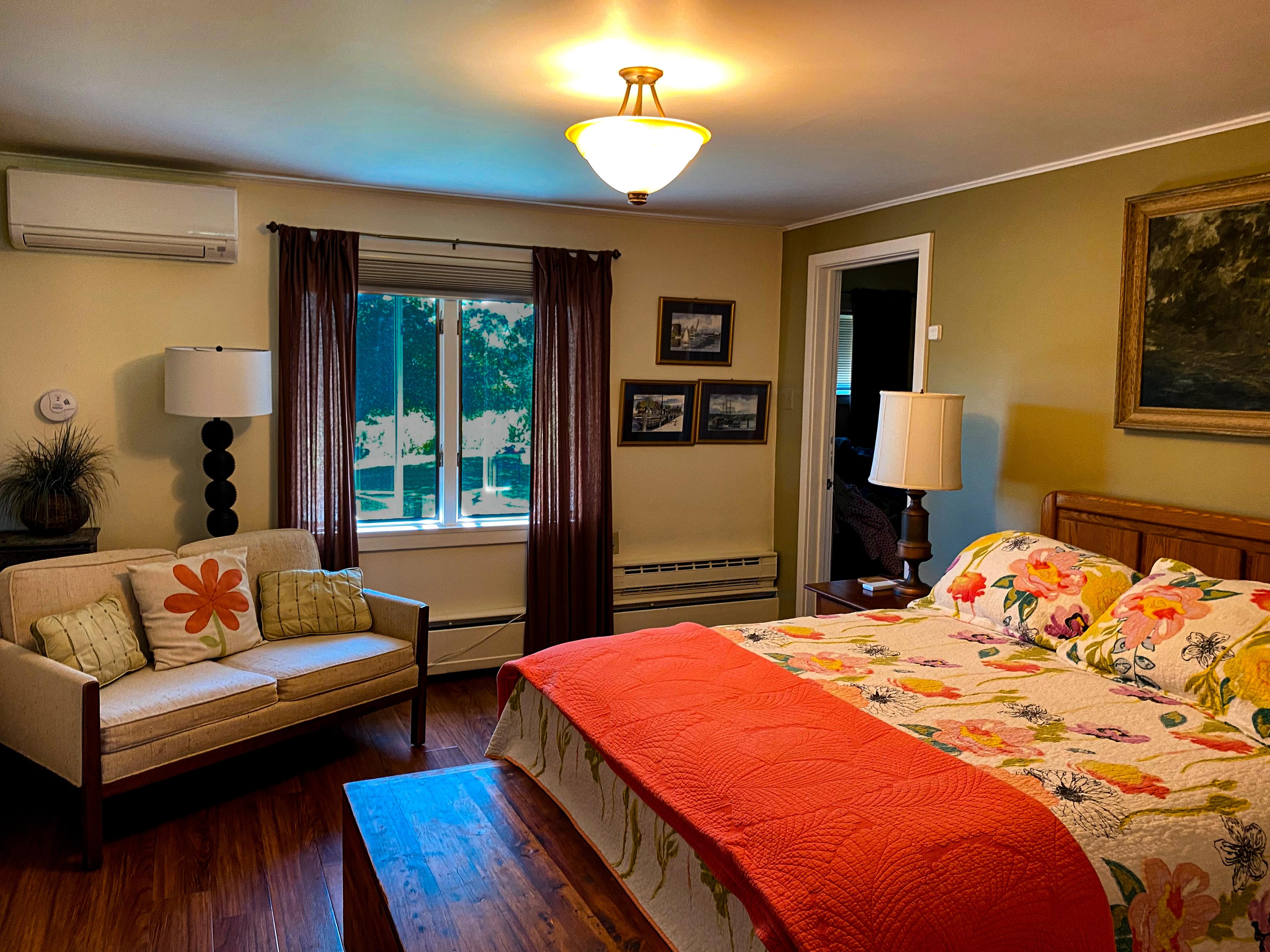 The master's sitting area: the fold-out couch by the window, with quiet AC on the wall above.