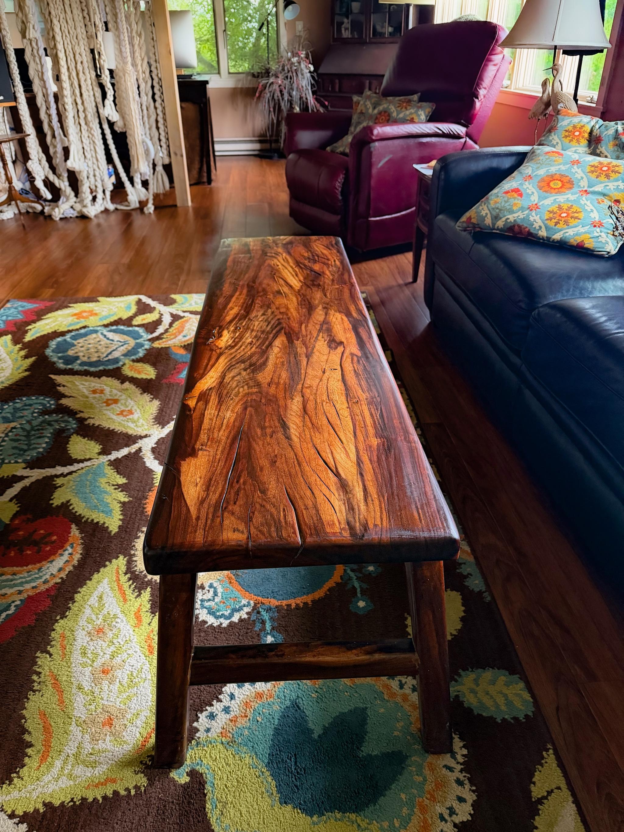 The goncalo alves coffee table in the living room, its figured grain under an oil finish