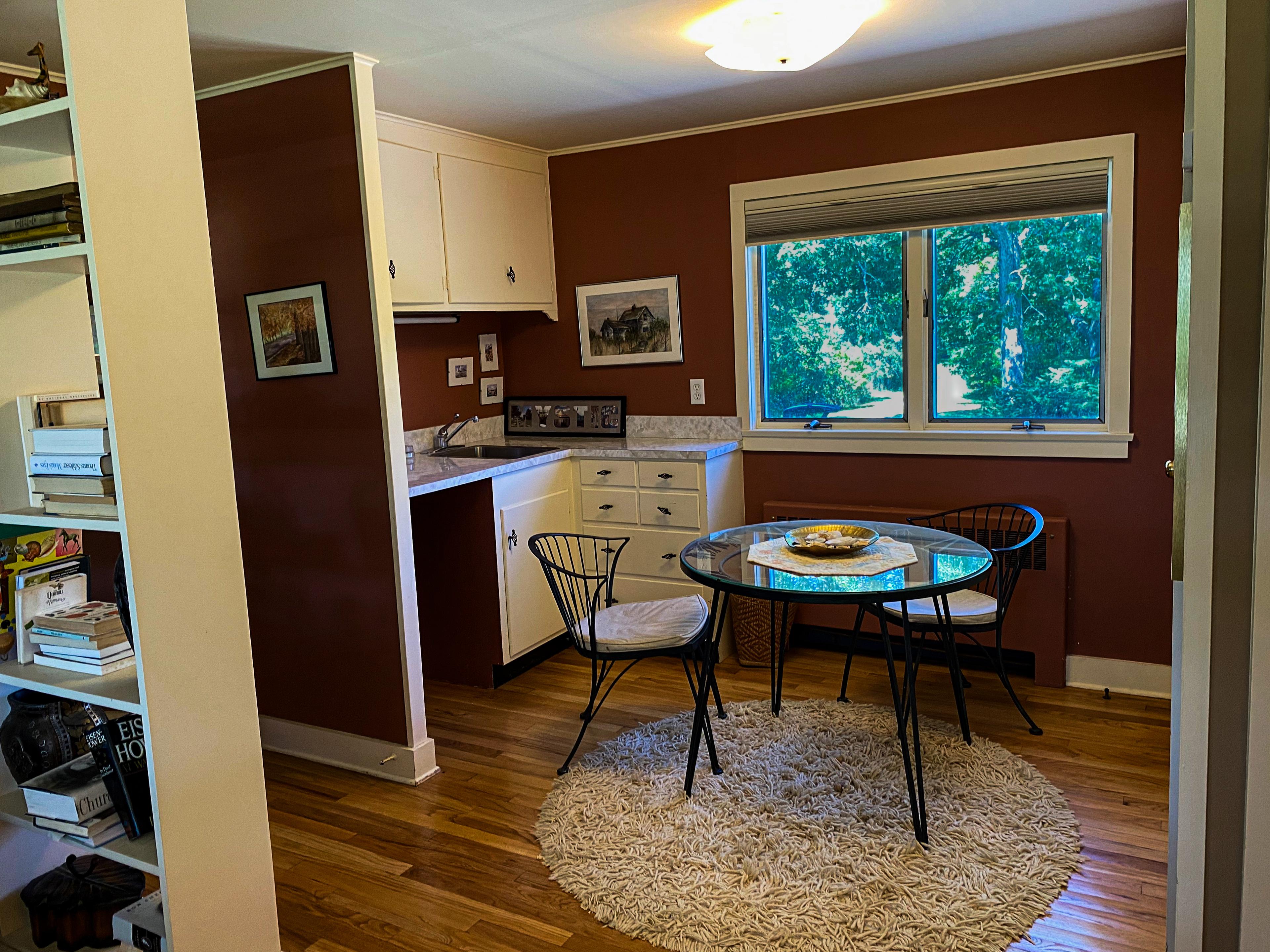 The crow's nest kitchenette: sink, counter, and a small café table by the window.