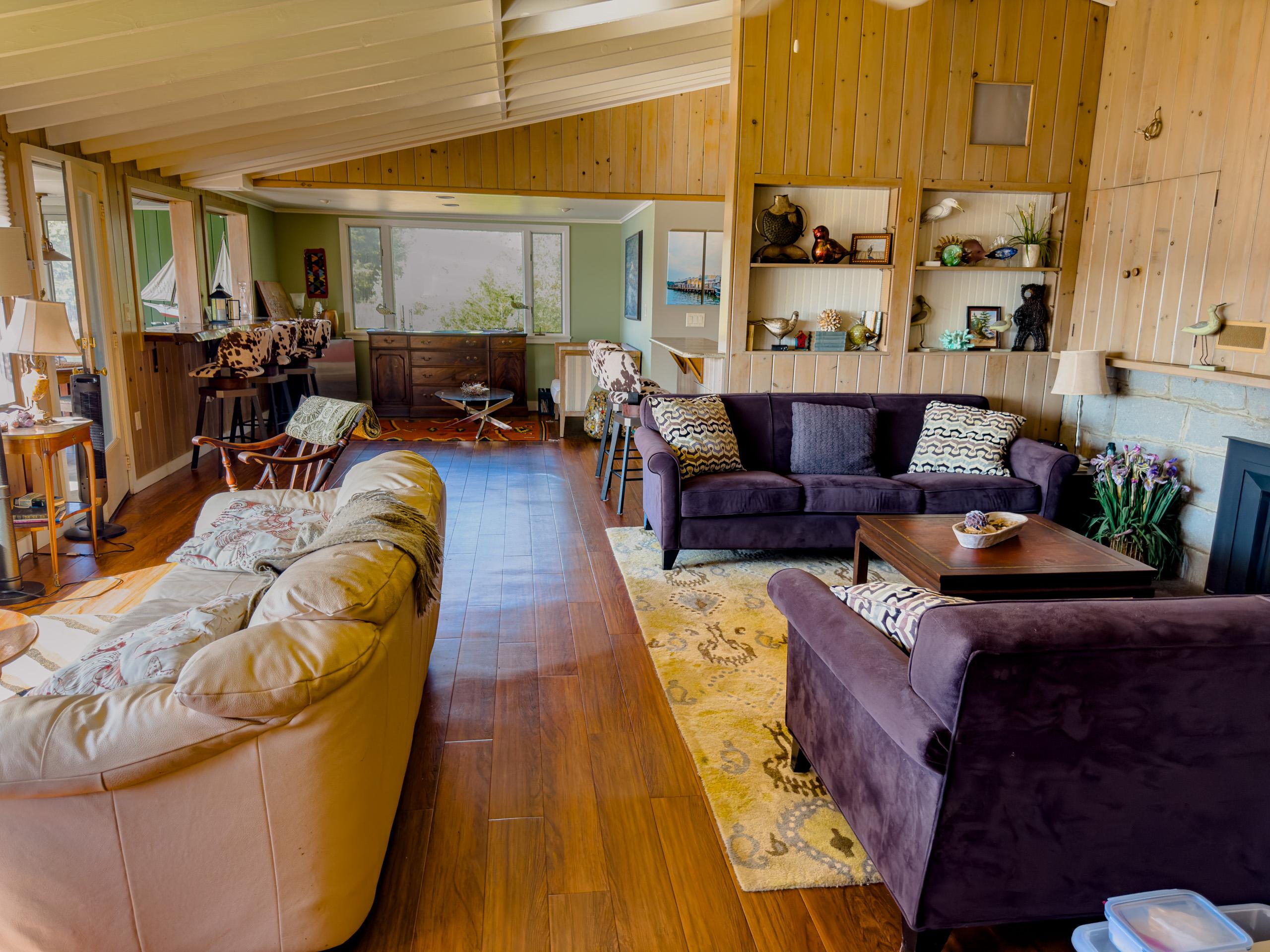 The living room, with the bar behind: big water windows and the gas fireplace for the off-season.
