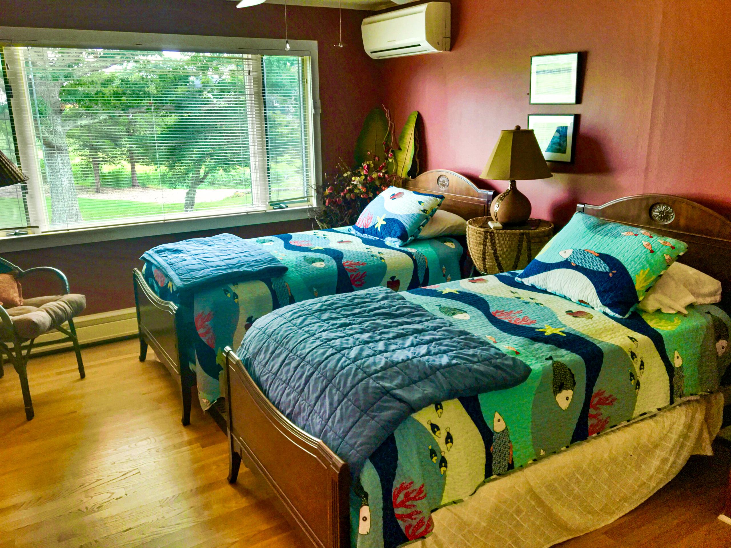 The red room: twin beds and the picture window down the lawn.