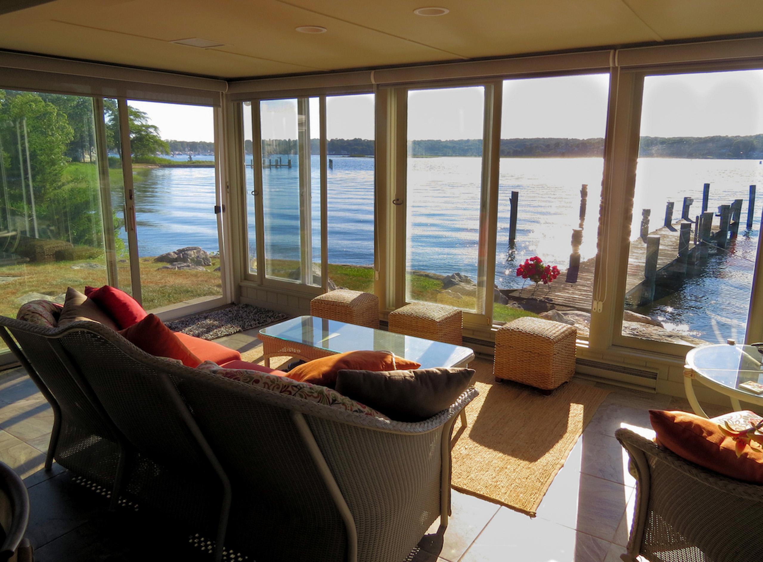 The sunroom: water filling every window, with the dock just outside.