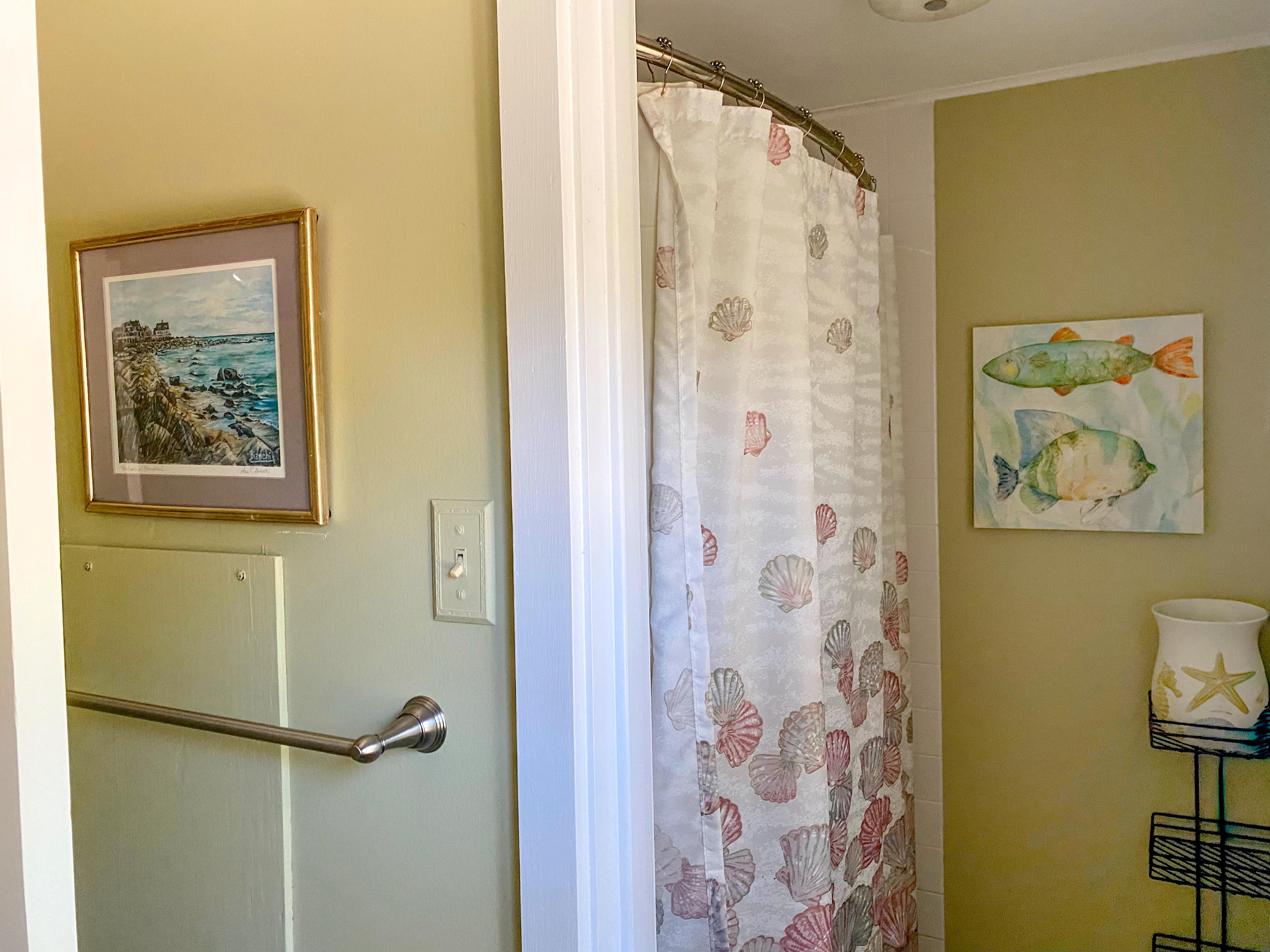 The upstairs bath: shell-print shower curtain and watercolor fish on the wall.
