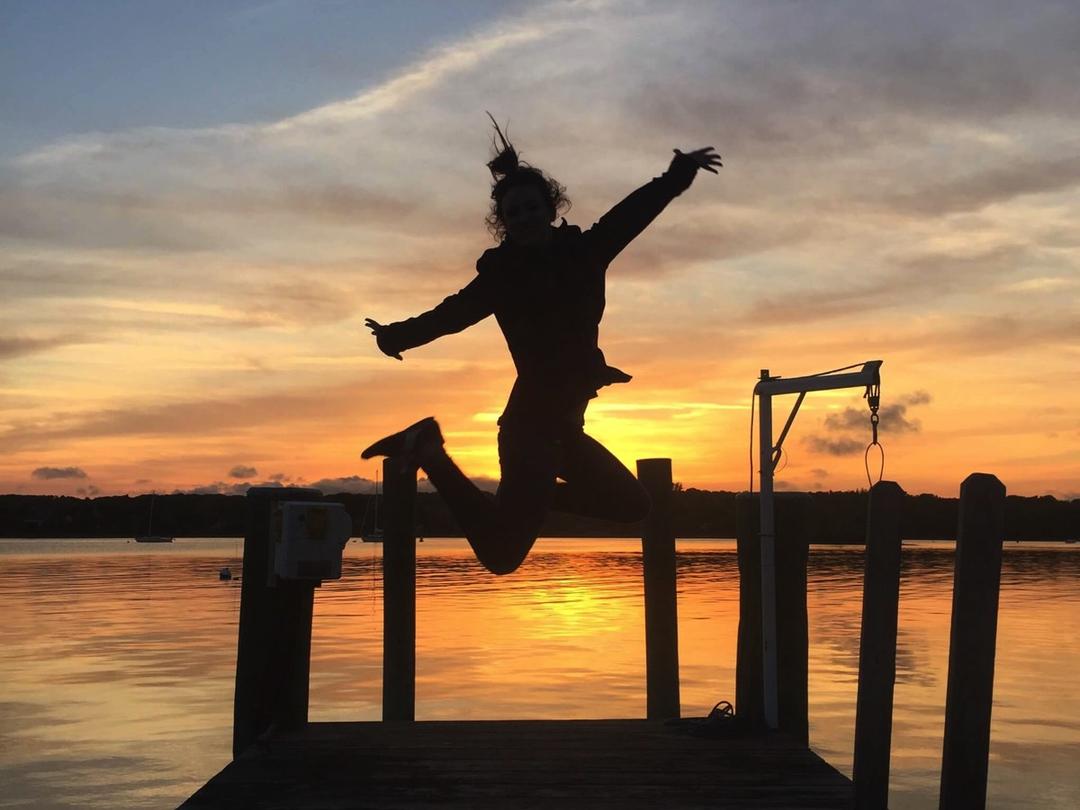 A leap off the dock, silhouetted against a Mystic River sunset