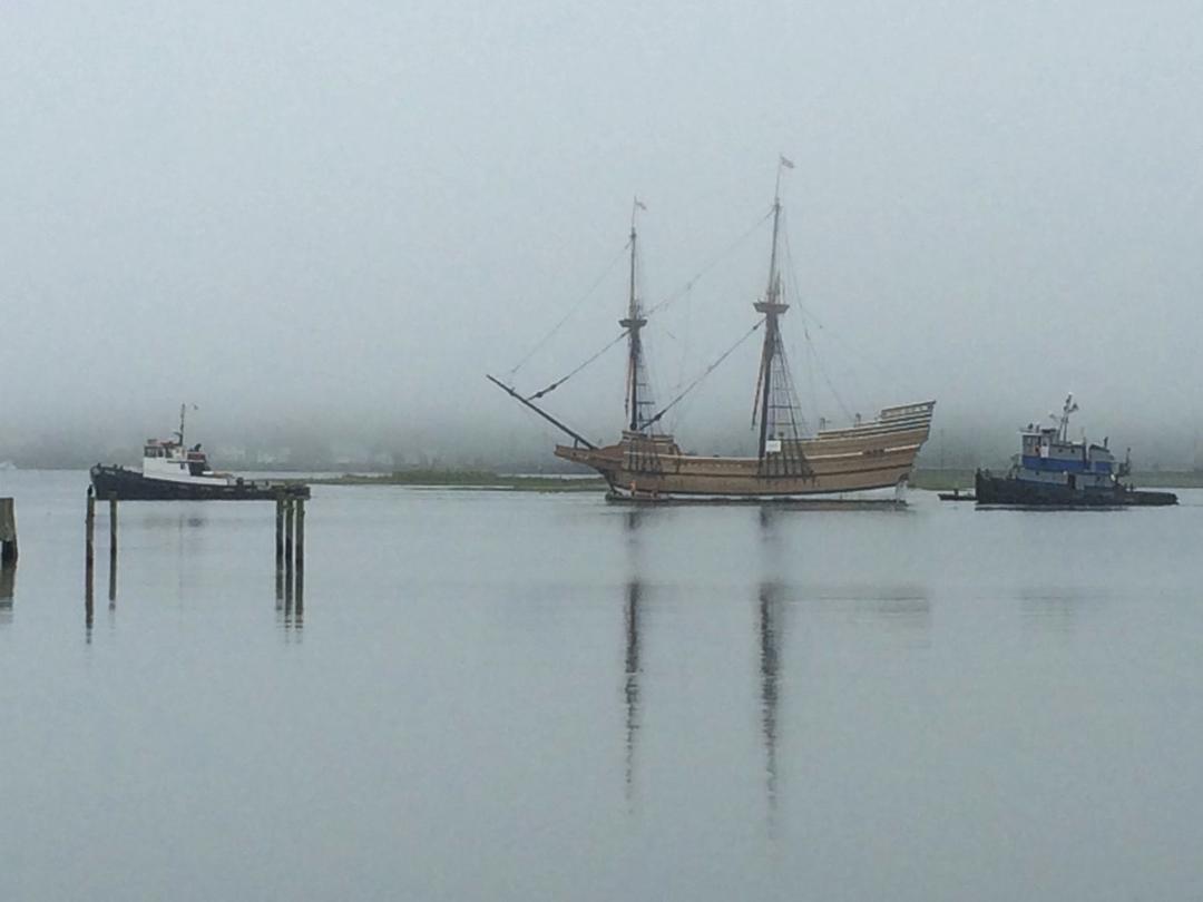 A tall ship under tow through the fog on the Mystic River